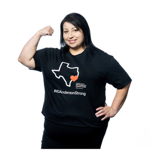 MD Anderson employee wearing a black shirt featuring a white outline of the map of Texas with a heart on Houston, accompanied by the white MD Anderson logo and the hashtag #MDAndersonStrong.