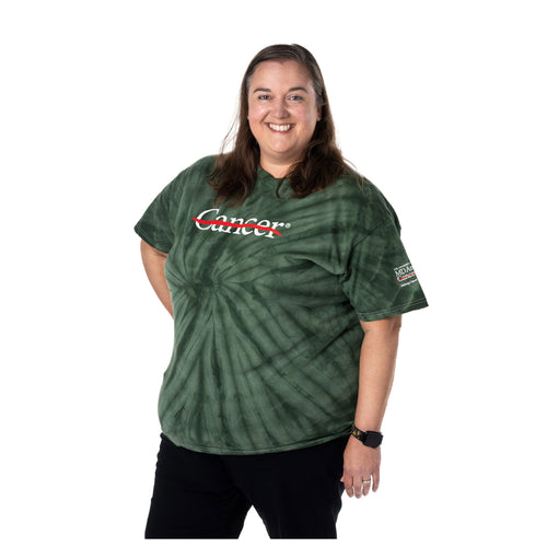 MD Anderson employee wearing a green tie-dye shirt featuring the white cancer strikethrough logo on the chest and the full MD Anderson logo on the sleeve.