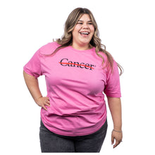 MD Anderson employee wearing a pink shirt featuring the black cancer strikethrough logo on the chest and the black MD Anderson logo on the sleeve.