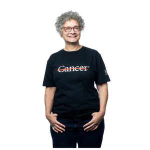 MD Anderson employee wearing a black shirt featuring the white cancer strikethrough logo on the chest and the white MD Anderson logo on the sleeve.
