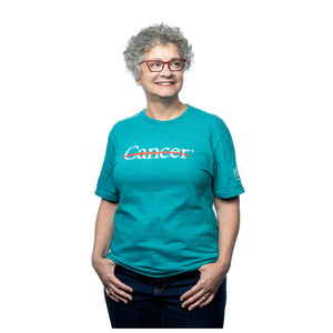 MD Anderson employee wearing a jade shirt featuring the white cancer strikethrough logo on the chest and the white MD Anderson logo on the sleeve.