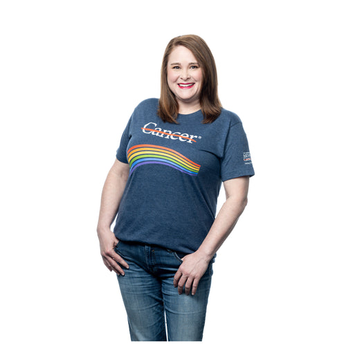 MD Anderson employee wearing the blue denim shirt featuring the white cancer strikethrough logo with a rainbow underneath and the white MD Anderson logo on the sleeve.