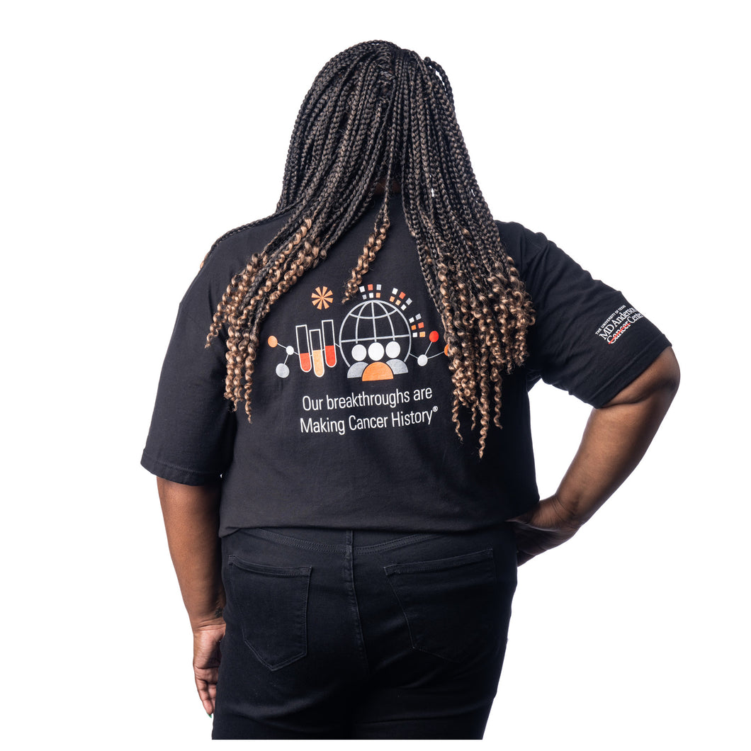 MD Anderson employee wearing the back of black t-shirt with research logo featuring the text 