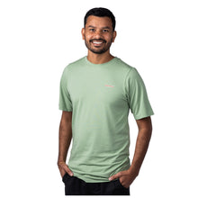 MD Anderson employee wearing a basil green shirt with the white cancer strikethrough logo on the chest area.