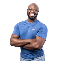 MD Anderson employee wearing a blue shirt featuring the white cancer strikethrough logo on the upper left chest area.