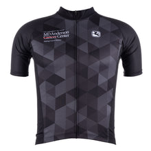 Black cycling jersey with a gray grid pattern featuring the white MD Anderson logo on the upper right chest area and the white GIORDADA logo on the upper left chest area.