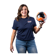 MD Anderson employee wearing a navy blue short-sleeve t-shirt with the white UT MD Anderson logo on the left chest, balancing an orange and white soccer ball on one hand.