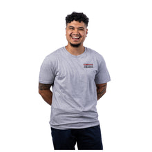 MD Anderson employee wearing a sport gray short-sleeve t-shirt with the black UT MD Anderson logo printed on the left chest area.