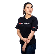 MD Anderson employee wearing a black shirt featuring the phrase "I heart MD Anderson" on the chest area and the white cancer strikethrough logo on the sleeve.