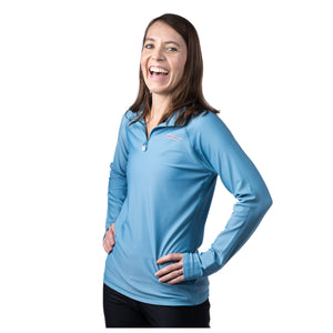 MD Anderson employee wearing a blue long sleeve 1/4 zip featuring the white cancer strikethrough logo on the top left chest area.