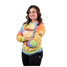 MD Anderson employee wearing a multicolor tie-dye long-sleeve shirt featuring the black Cancer strikethrough logo across the chest and the UT MD Anderson logo on the sleeve.