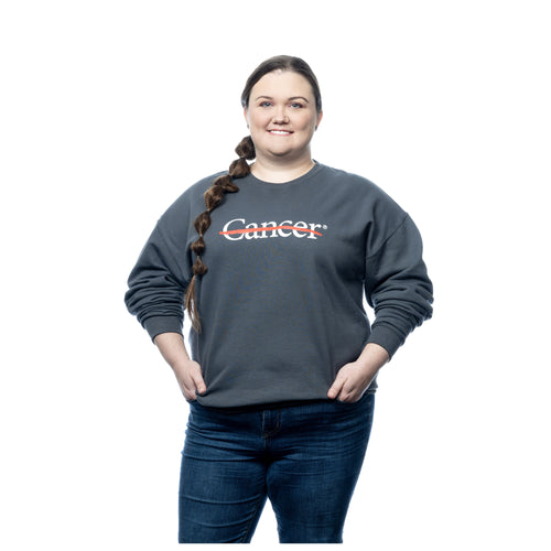 MD Anderson employee wearing a gray crewneck featuring the white cancer strikethrough logo on the chest.