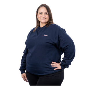 MD Anderson employee wearing a navy Champion fleece crewneck featuring the white cancer strikethrough logo on the upper left side of the chest.