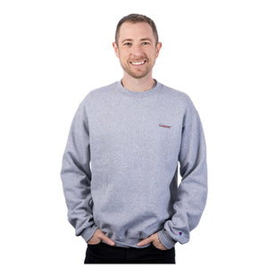 MD Anderson employee wearing a gray Champion fleece crewneck featuring the black cancer strikethrough logo on the upper left side of the chest.