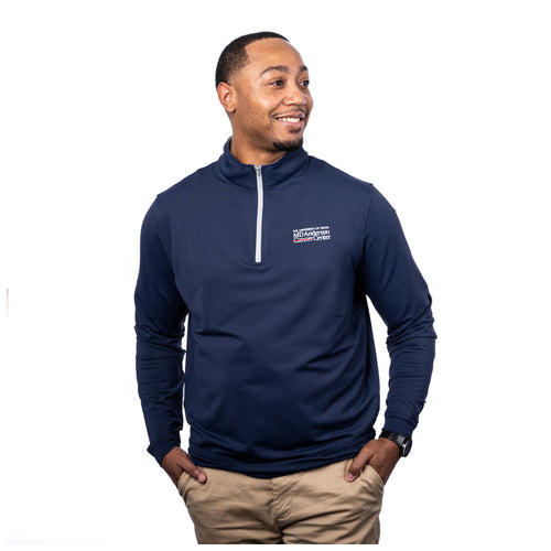 MD Anderson employee wearing a navy Peter Millar 1/4 zip featuring the full white MD Anderson logo on the upper left chest area.