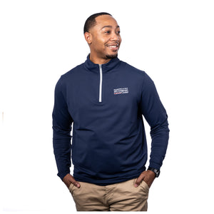 MD Anderson employee wearing a navy Peter Millar 1/4 zip featuring the full white MD Anderson logo on the upper left chest area.