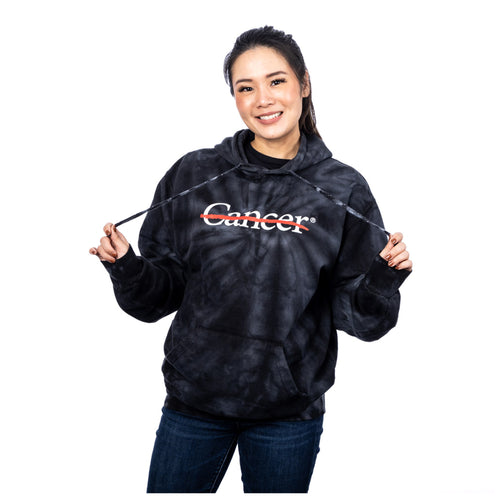 MD Anderson employee wearing a black tie-dye hoodie featuring the white cancer strikethrough logo on the chest area.