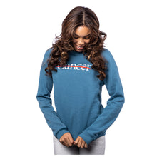 MD Anderson employee wearing a heather teal crewneck featuring the white cancer strikethrough logo in the middle.