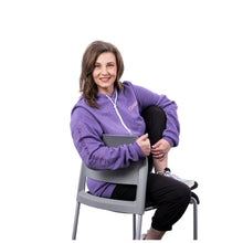 MD Anderson employee wearing a heather purple hooded sweatshirt featuring the white Cancer strikethrough logo on the left chest, a kangaroo pouch pocket, and "Making Cancer History" printed down the right sleeve.