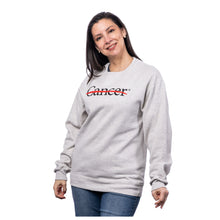 MD Anderson employee wearing a heather oatmeal crewneck featuring the black cancer strikethrough logo in the middle chest area.