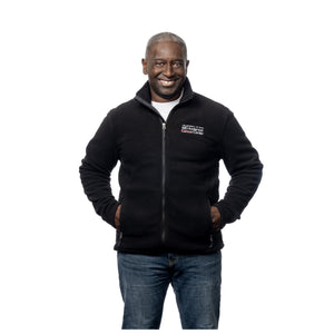 MD Anderson employee wearing a black zippered fleece jacket featuring the white MD Anderson logo on the chest area.