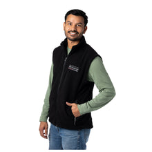 MD Anderson employee wearing a black fleece zippered vest with the white MD Anderson logo embroidered on the chest area.