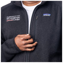 Closeup of MD Anderson employee wearing a black Patagonia fleece jacket with full zip featuring the white MD Anderson logo on one side and the Patagonia logo on the other side.