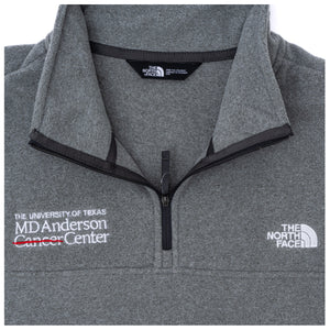 Closeup of gray North Face fleece jacket featuring the white MD Anderson logo on the right side of the chest and the white North Face logo on the left side of the chest, featuring a quarter-zip.