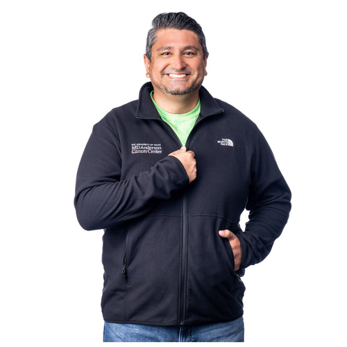 MD Anderson employee wearing a black North Face fleece jacket featuring the white MD Anderson logo on the right side of the chest and the white North Face logo on the left side of the chest, featuring a full zipper and front zippered-pockets.