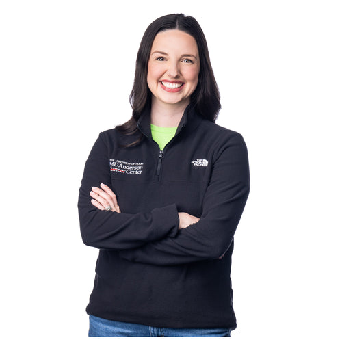 MD Anderson employee wearing a black quarter-zip North Face jacket with the white MD Anderson logo featured on the right side of the chest, and the white North Face logo on the left side of the chest.