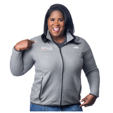 MD Anderson employee wearing a gray North Face jacket with a full zip in the middle, featuring the white MD Anderson logo on the right side of the chest, and the white North Face logo on the left side of the chest.