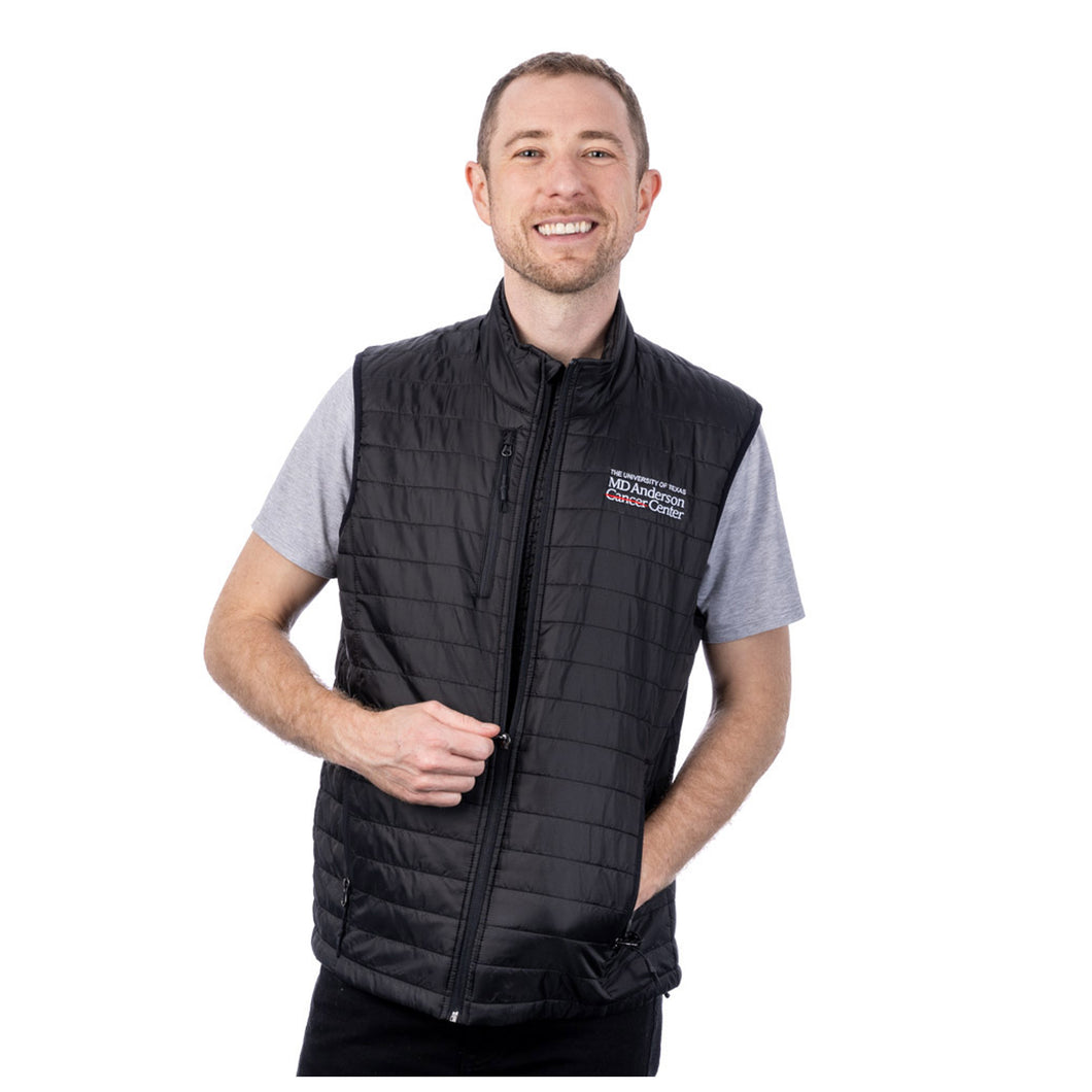 MD Anderson employee wearing a black puffy zippered vest with front pockets featuring the full white MD Anderson logo on the top left chest area.