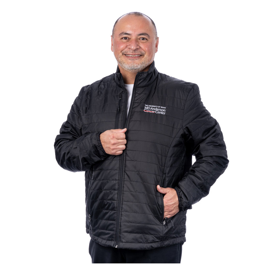 MD Anderson employee wearing a black puffy zippered jacket with front pockets featuring the full white MD Anderson logo on the top left chest area.