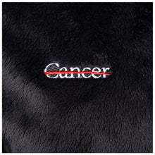 Closeup of the white cancer strikethrough logo.