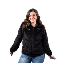 MD Anderson employee wearing a black North Face fleece jacket featuring the white Cancer strikethrough logo on the right chest and a gray North Face logo on the left chest.