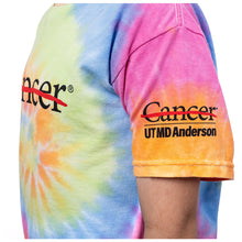 Side view of youth tie-dye shirt featuring the black cancer strikethrough logo on the chest area and the black UT MD Anderson logo on the sleeve.