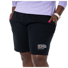 MD Anderson employee wearing a black fleece shorts featuring the white MD Anderson logo on the bottom corner of the leg.