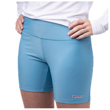 MD Anderson employee wearing lagoon blue shorts featuring the white cancer strikethrough logo at the bottom left seam.