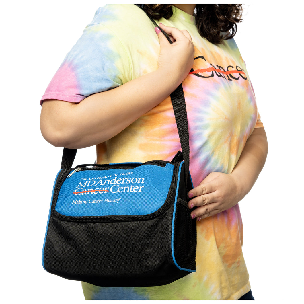MD Anderson employee holding a blue and black lunch bag with the white MD Anderson logo displayed on the front.