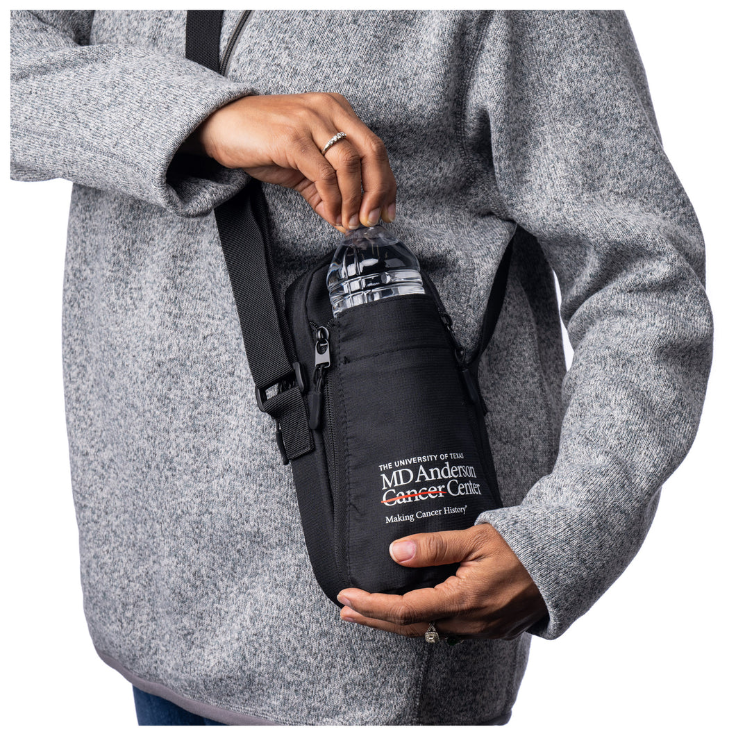 Closeup of MD Anderson employee holding a black water bottle bag featuring the white MD Anderson logo.