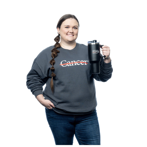 MD Anderson employee holding a black 40 oz. travel mug with a straw and handle, featuring the MD Anderson logo on the front.