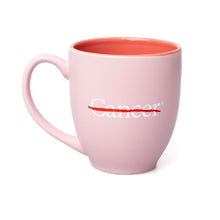 Back of a pink mug featuring the white cancer strikethrough logo in the middle.