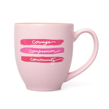 Pink mug featuring the words "courage, compassion, and community".