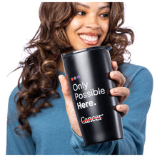 MD Anderson employee holding a black tumbler with plastic lid featuring the tagline "Only Possible Here" with the white cancer strikethrough logo.