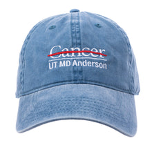 Baseball cap in denim featuring the full white UT MD Anderson logo embroidered on the front.