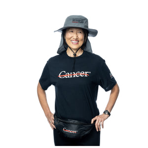 MD Anderson employee wearing a gray sun brim hat with neck protector featuring the black MD Anderson logo on it, and also wearing the black cancer strikethrough t-shirt.