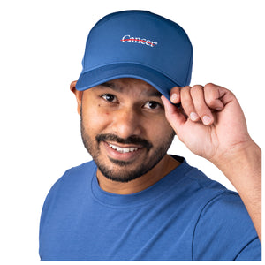 MD Anderson employee wearing a blue cap featuring the white cancer strikethrough logo in the middle.