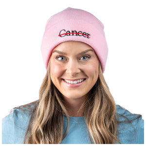 MD Anderson employee wearing a pink beanie featuring the black cancer strikethrough logo.