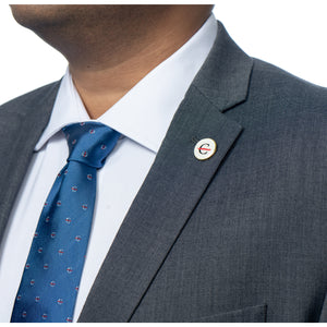 MD Anderson employee wearing a round white lapel pin featuring the strikethrough 'C', and also wearing a blue silk tie with the strikethrough 'C' pattern