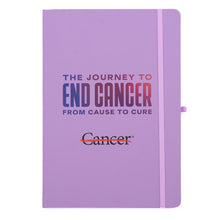 Lilac journal featuring the multicolor gradient tagline "The Journey to End Cancer from Cause to Cure" and the black cancer strikethrough logo, with a ribbon closure and a black-ink pen on the side.